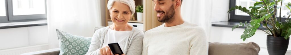 elderly woman and young man holding cell phone